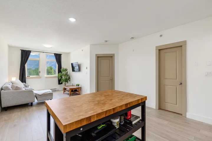 Open-concept living area featuring light wood-finish flooring, recessed lighting, and a butcher block island