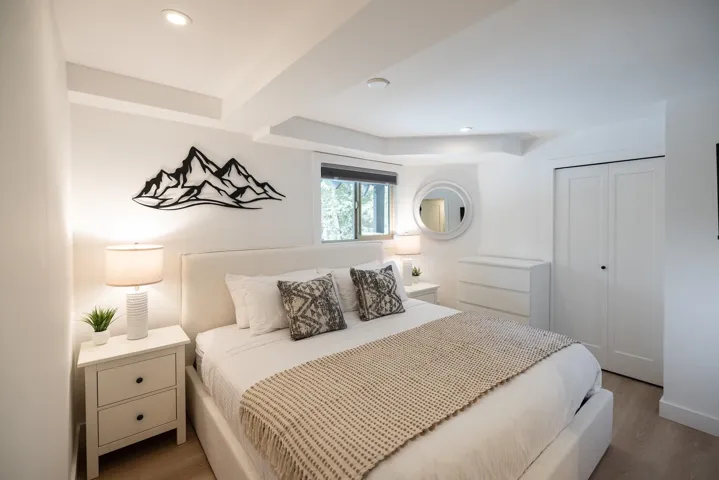 Bedroom featuring light wood-finish flooring, recessed lighting, and a window with a roller shade