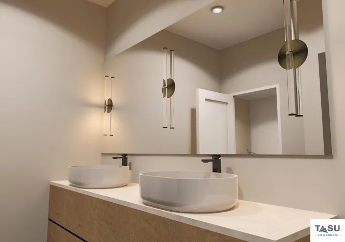 Double vessel sinks with matte black fixtures, set on a light-toned countertop, above a wood-finish vanity with dark accents