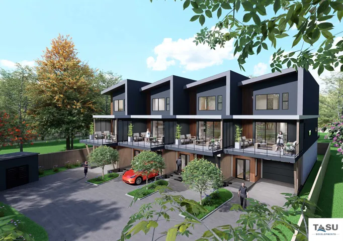 Modern multi-level townhomes featuring dark gray facades, private balconies with glass railings, and individual garages