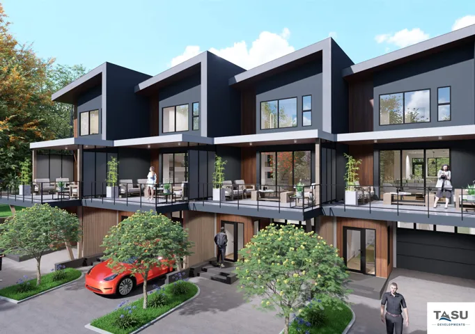 Modern townhome exterior featuring a split-level design with balconies, expansive windows, and an integrated garage