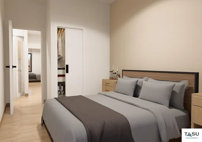 Bedroom featuring light wood-finish flooring, a built-in closet with sliding doors, and a neutral wall color
