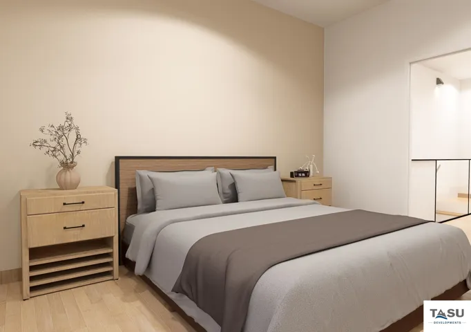 Bedroom featuring light-colored walls and wood-finish flooring