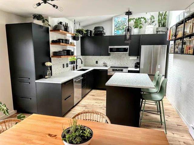Kitchen featuring open shelves, appliances with stainless steel finishes, a center island, light wood-style flooring, and dark cabinets