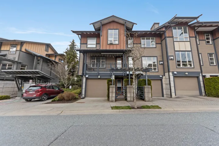 Townhome / multi-family property featuring driveway, board and batten siding, and an attached garage