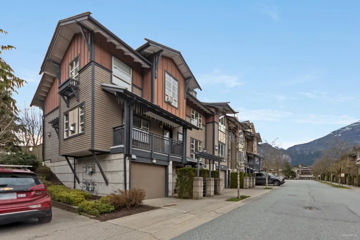 View of building exterior featuring a mountain view, a residential view, and a garage