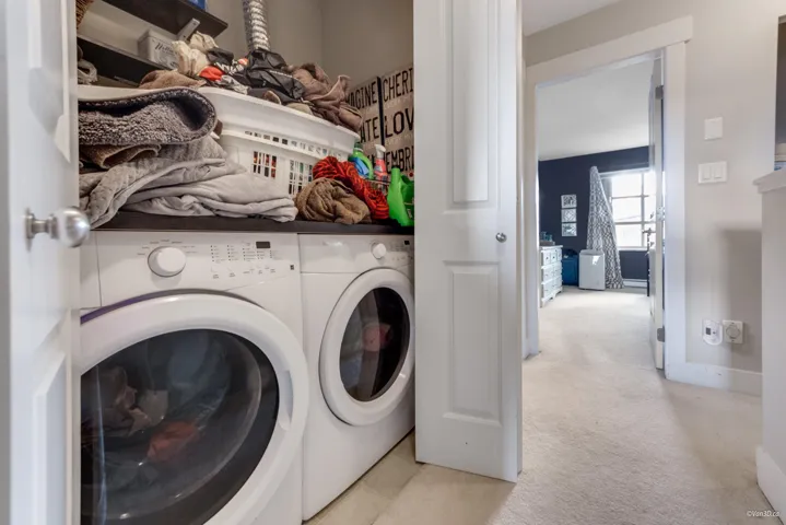 Laundry area with light carpet, independent washer and dryer, laundry area, and baseboards