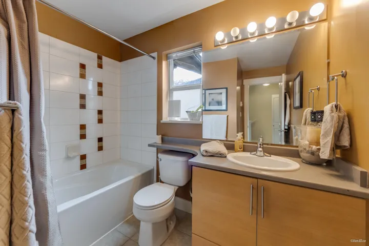Full bath with tile patterned flooring, shower / tub combo, vanity, and toilet