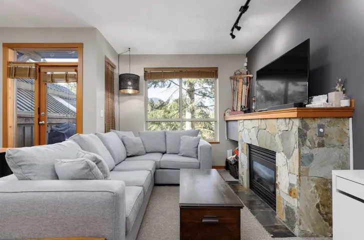 Living area with track lighting and a stone fireplace