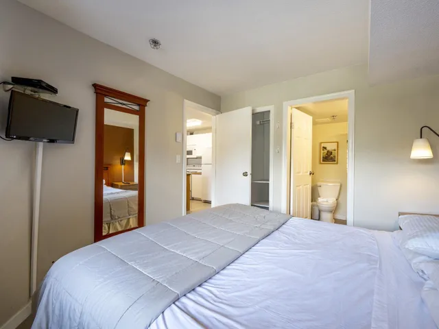 Bedroom featuring ensuite bath and freestanding refrigerator