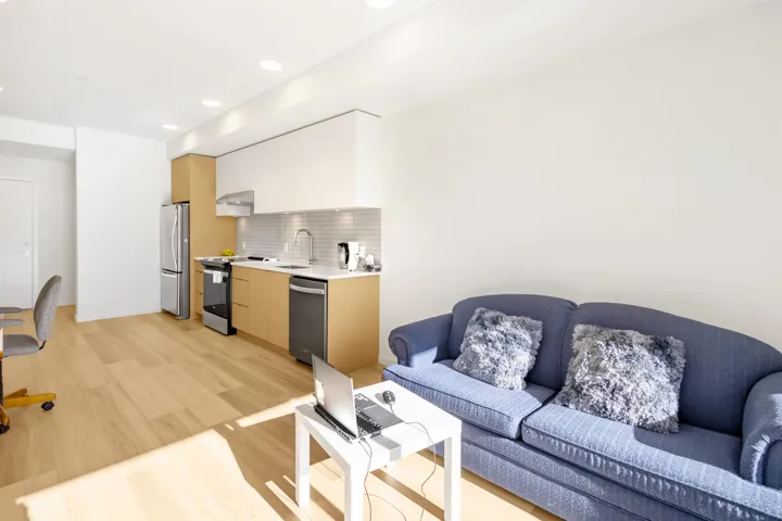 Living area with light wood-style flooring and recessed lighting
