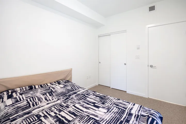 Bedroom featuring light carpet and a closet