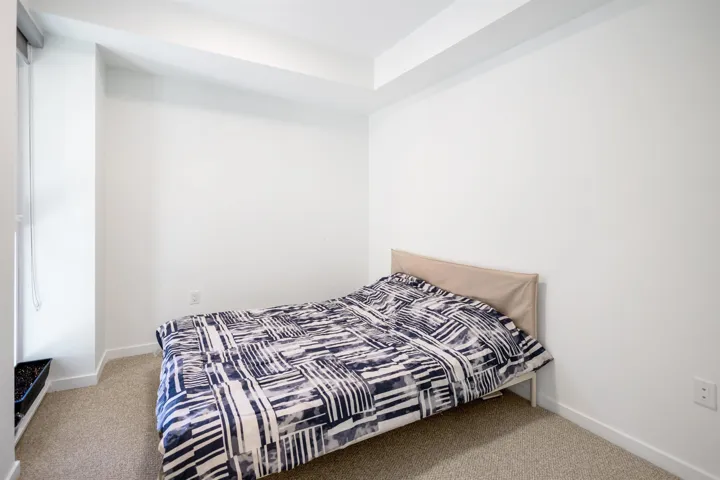 Bedroom featuring light carpet and baseboards
