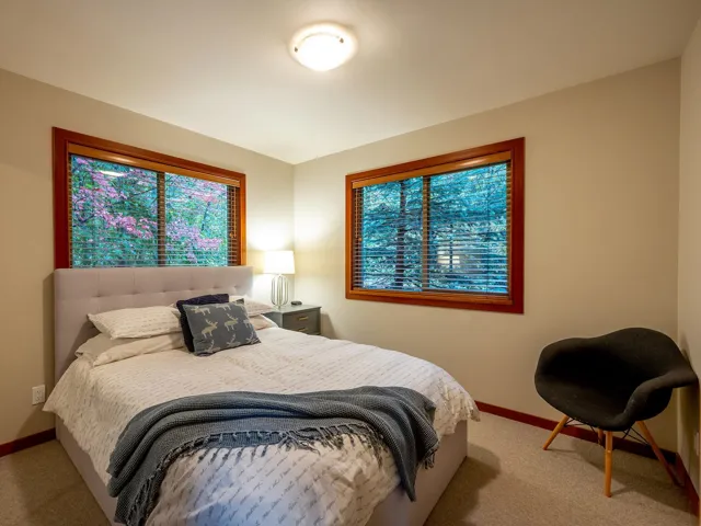 Bedroom with light carpet and multiple windows