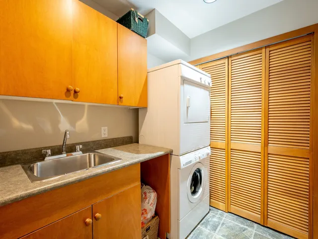 Washroom with stacked washing machine and dryer and cabinet space