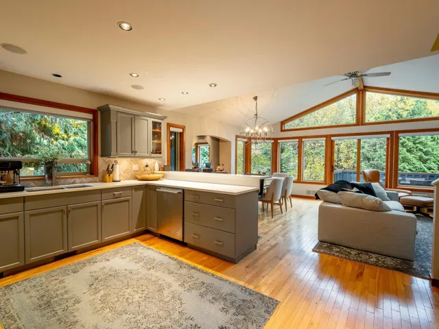 Kitchen featuring gray cabinetry, light wood-style flooring, hanging light fixtures, a peninsula, and a chandelier