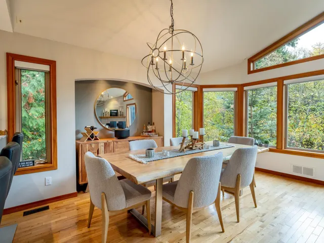 Dining room with light wood-style flooring, a chandelier, and lofted ceiling