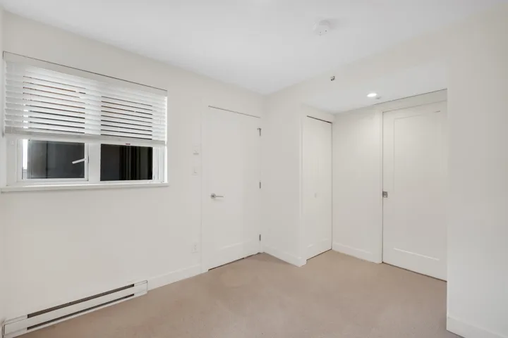 Unfurnished bedroom with baseboard heating, light colored carpet, and recessed lighting