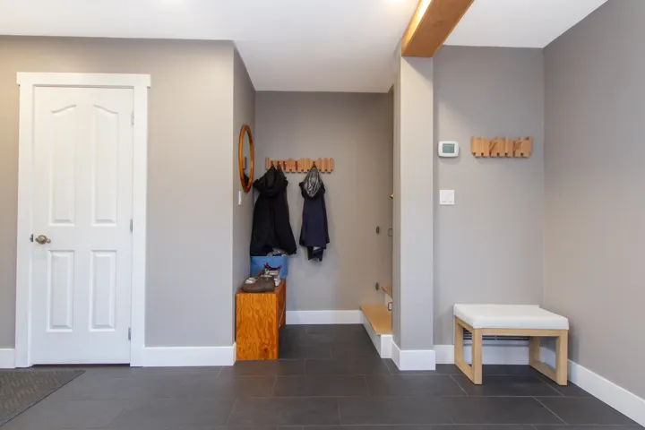 Mudroom featuring dark tile patterned floors and baseboards