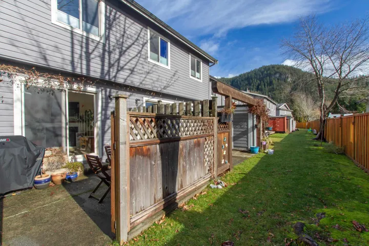 View of yard featuring fence private yard, a storage shed, a mountain view, and an outdoor structure