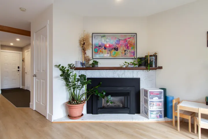 Living area with wood finished floors, recessed lighting, a glass covered fireplace, and baseboards