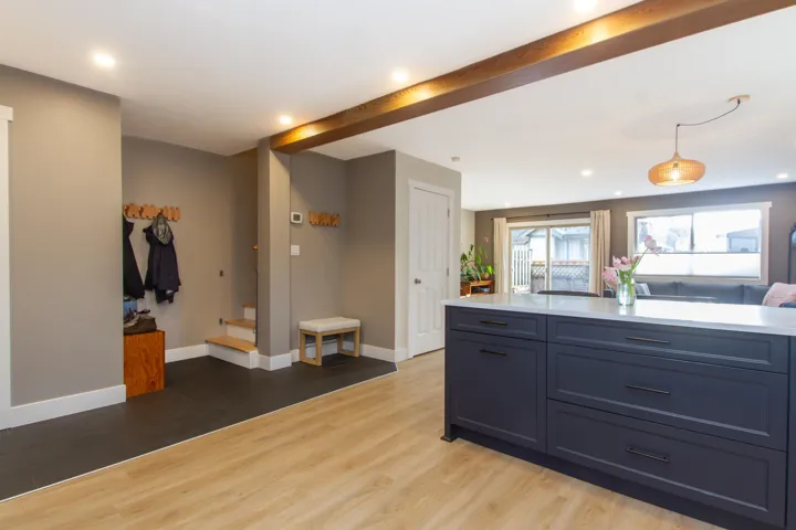 Kitchen featuring beam ceiling, light countertops, and wood finished floors
