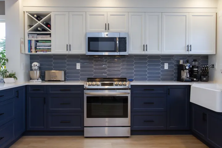 Kitchen with appliances with stainless steel finishes, light countertops, white cabinetry, and light wood finished floors