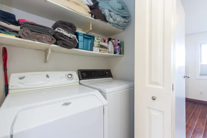 Laundry area featuring washer and dryer, laundry area, and dark wood finished floors