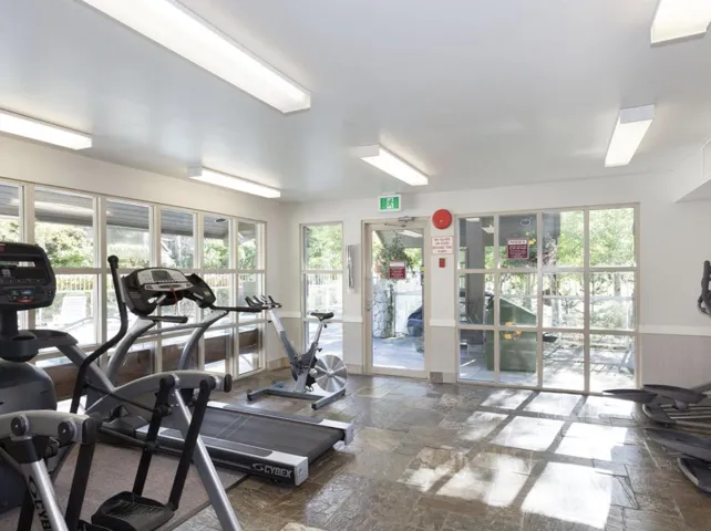 Gym featuring stone tile floors and healthy amount of natural light