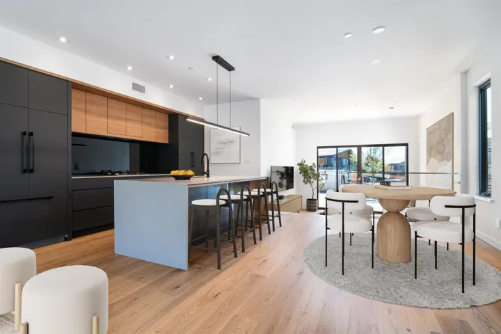 Kitchen featuring an island with sink, a kitchen bar, light wood-type flooring, and modern cabinets