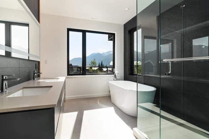 Bathroom with a mountain view, a freestanding bath, a stall shower, and a sink
