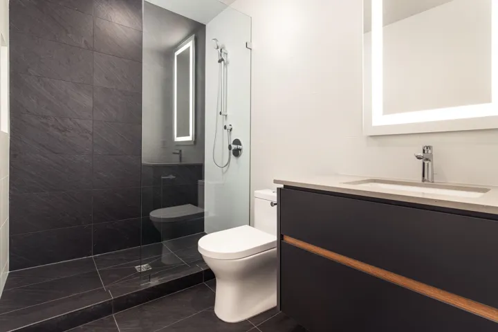 Bathroom featuring toilet, tile patterned flooring, a walk in shower, and vanity