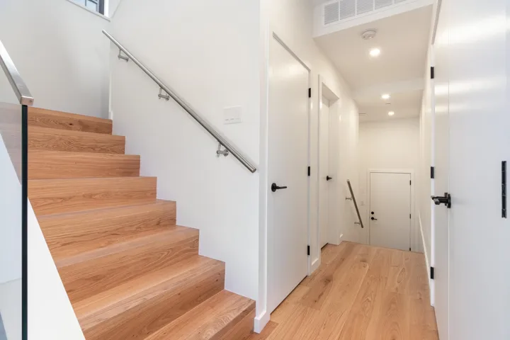 Staircase with recessed lighting, visible vents, and wood finished floors