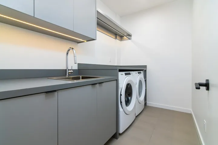 Washroom with washer and dryer, a sink, cabinet space, and baseboards