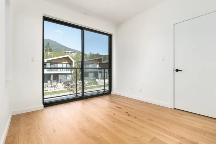 Unfurnished room featuring wood finished floors, a healthy amount of sunlight, and baseboards