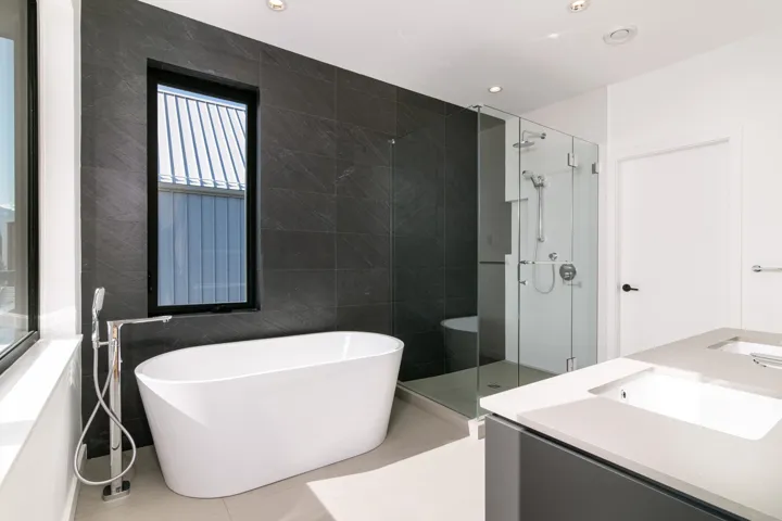 Bathroom with tile patterned flooring, tile walls, a sink, a soaking tub, and a stall shower