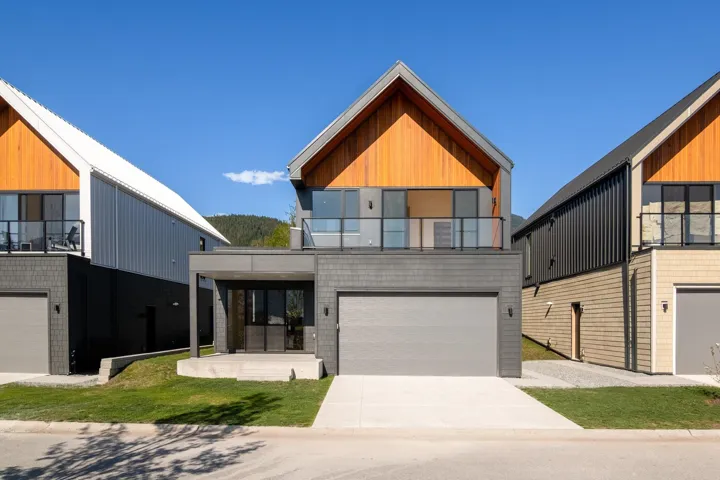 Contemporary house featuring driveway, a balcony, and an attached garage