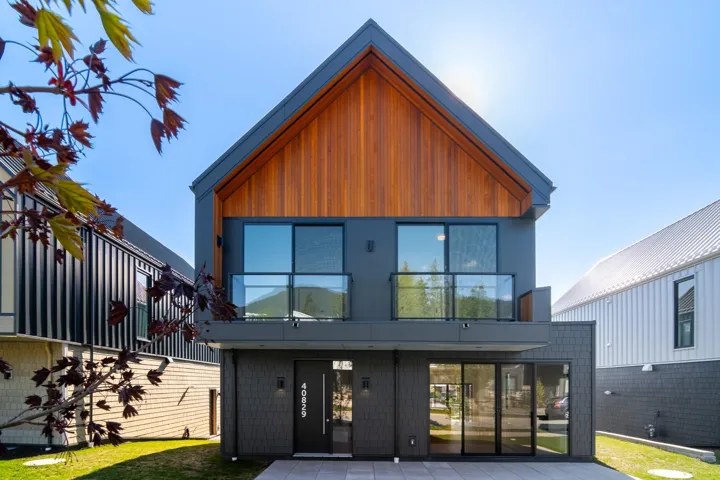 Back of house featuring a yard and a balcony