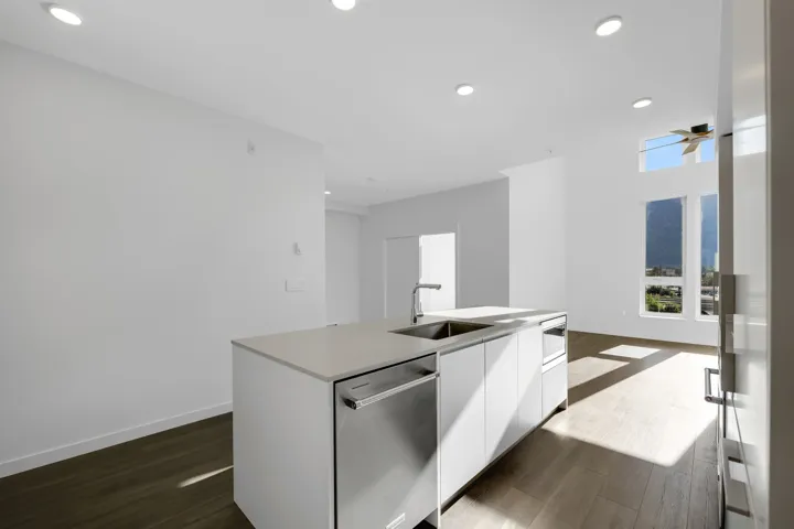 Kitchen featuring dishwasher, dark wood-style flooring, white cabinets, a kitchen island with sink, and recessed lighting