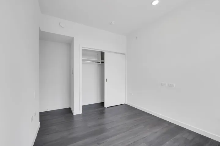 Unfurnished bedroom featuring dark wood-style floors, a closet, and recessed lighting