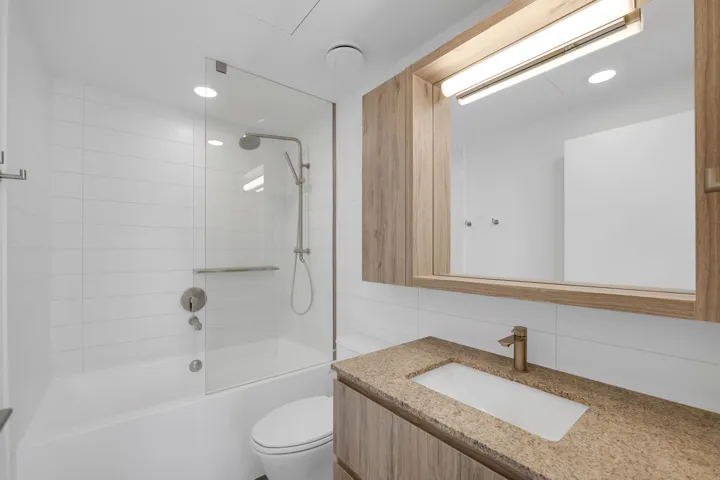Full bath featuring vanity, shower / tub combination, tile walls, and recessed lighting