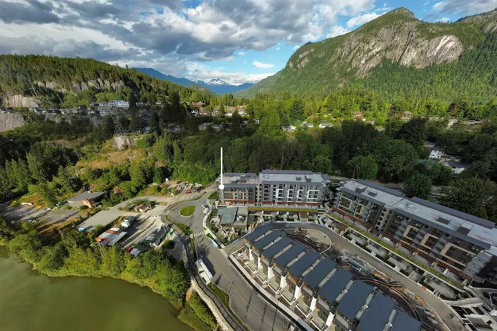 Aerial view of property and surrounding area with a mountainous background and a heavily wooded area