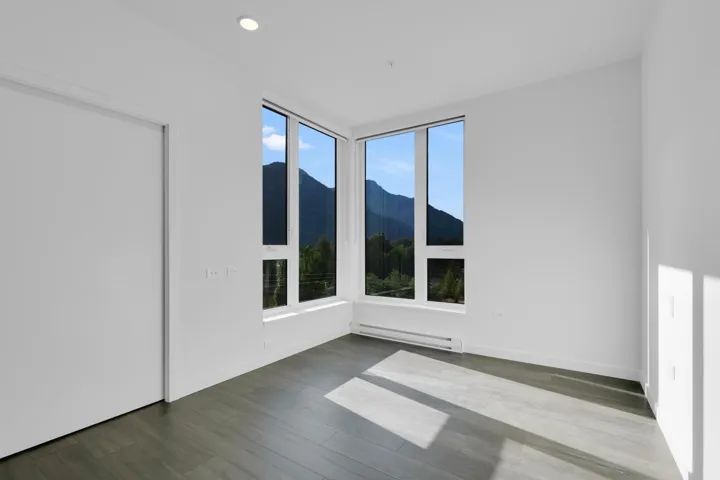 Spare room featuring dark wood-type flooring, a baseboard radiator, recessed lighting, and a mountain view