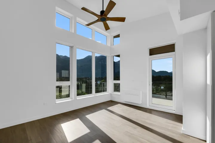 Unfurnished sunroom featuring a mountain view, wood finished floors, and a high ceiling