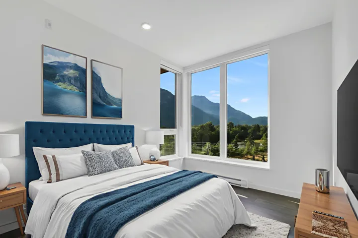 Bedroom with multiple windows, wood finished floors, recessed lighting, and a baseboard heating unit