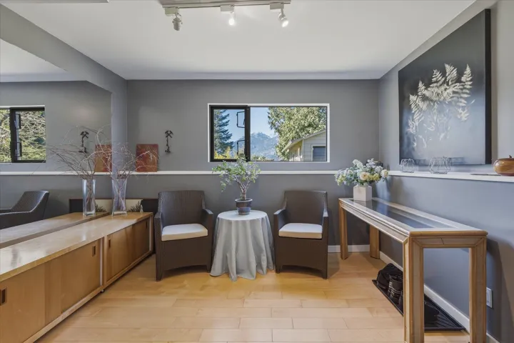 Sitting room featuring light wood-type flooring and healthy amount of natural light