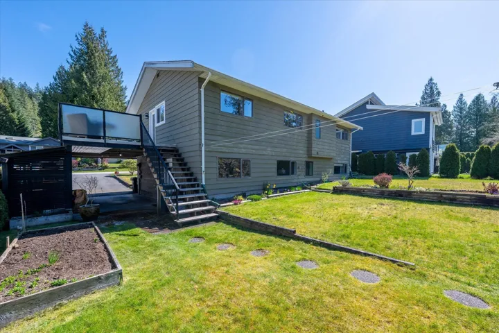 Rear view of house with a lawn and a deck