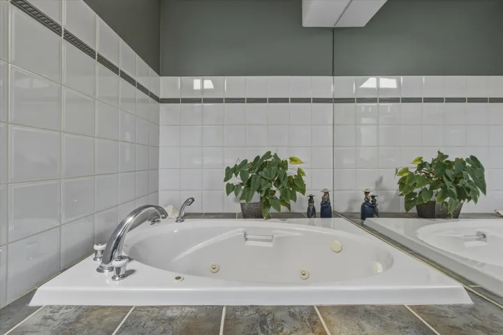 Bathroom with a whirlpool tub and tile walls