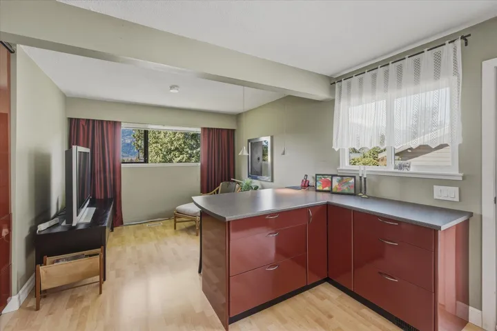 Kitchen with light wood-type flooring, a peninsula, and stainless steel counters