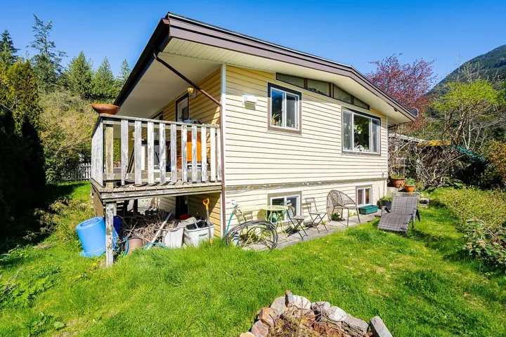 Back of house featuring a wooden deck and a lawn